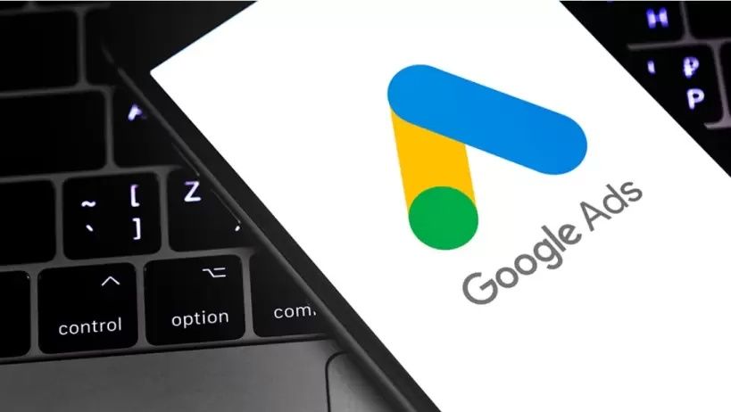 phone resting on laptop keyboard with the Google Ads logo displayed on phone screen